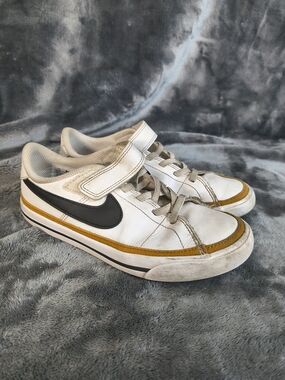 Nike White Low-Top Sneakers with Black Swoosh and Gold Accent